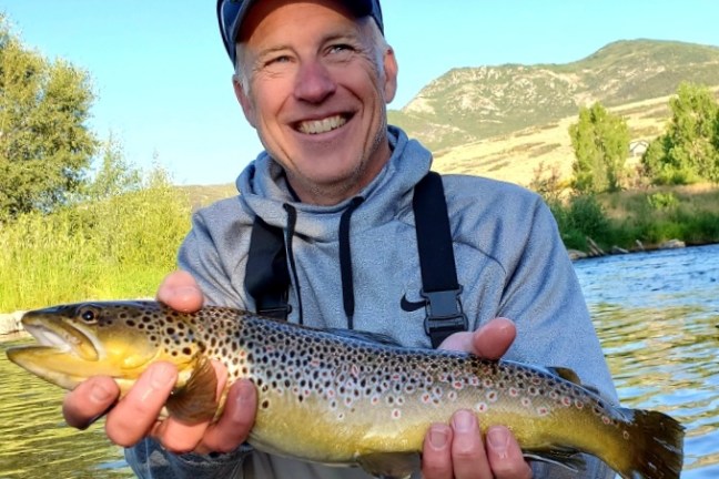 a man holding a fish in the water