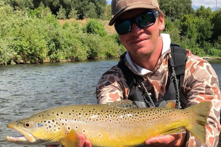 a man holding a fish in the water