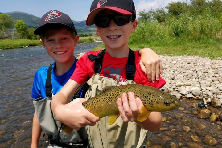 a young boy holding a fish