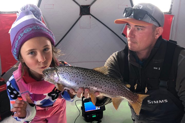 a man holding a little girl wearing a hat and sunglasses