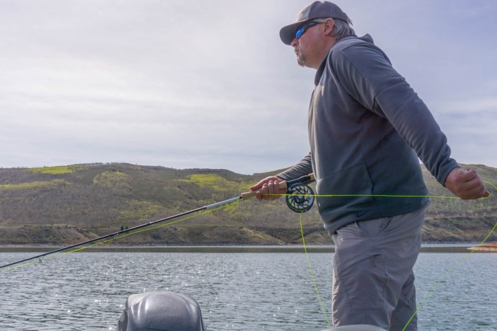 a man standing next to a body of water